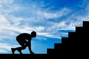 A man standing at the bottom of steep steps, preparing to climb, symbolising challenge and effort to communicate.